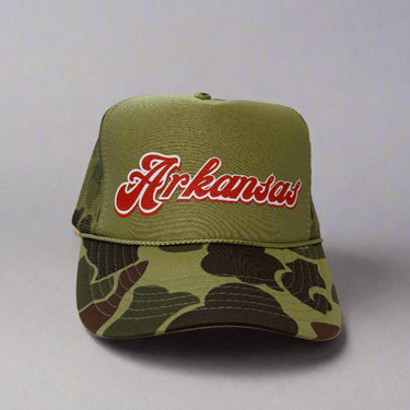 Green camouflage trucker hat with 'Arkansas' in red on a light gray background