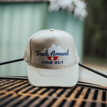 Khaki trucker hat with 'Truck Around & Find Out' text and mountain design product shot