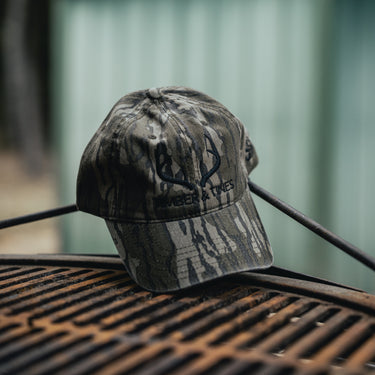 Mossy Oak Bottomland Camouflage cap with 'Timber & Tines' product shot