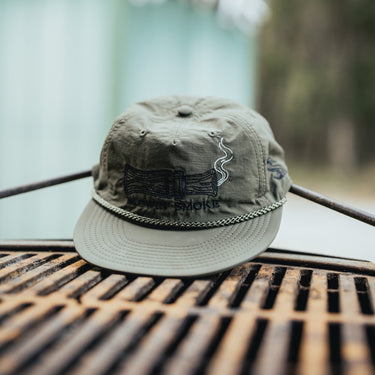 Olive green hat with blowin smoke text and duck call with smoke detail