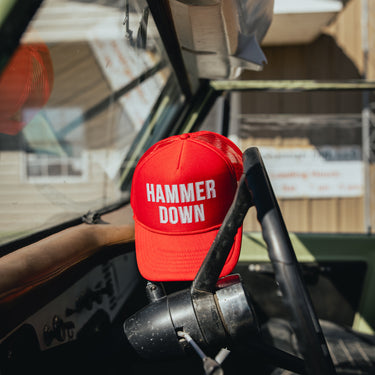 hammer down left lane trucker hat on steering wheel